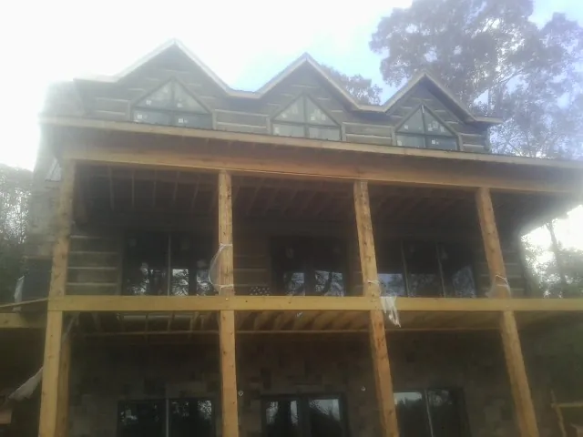 Dormers and porch framing on a large log home under construction — Roof Coating work by our crew in Pawtucket