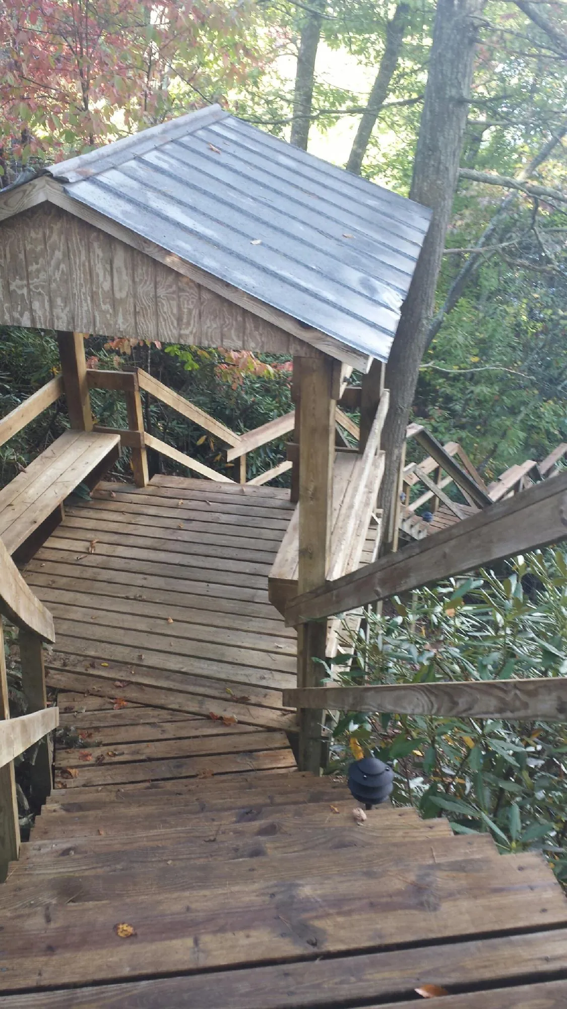 Metal roofed shelter over wooden steps on a wooded walkway — Skylight Repair & Installation work by our crew in Pawtucket