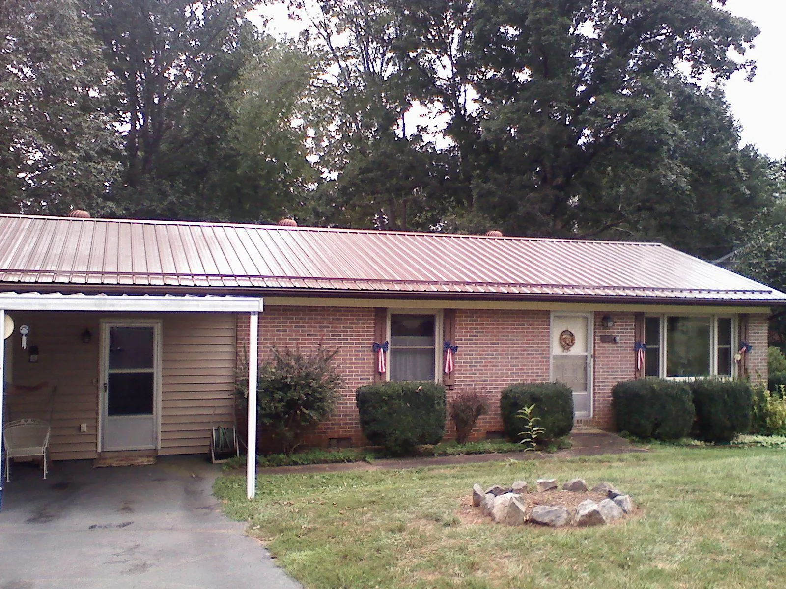 Bronze metal roof and carport on a brick ranch home — Roof Repair work by our crew in Pawtucket